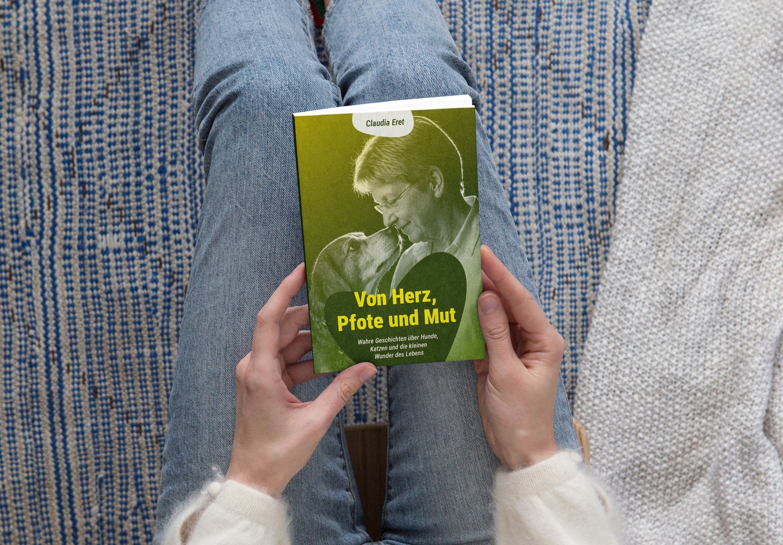Das Buch „Von Herz, Pfote und Mut“ von Claudia Eret in den Händen einer Leserin